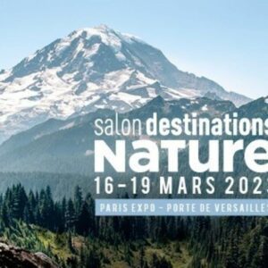 Une randonneuse, en haut d'une montagne regardant l'horizon
